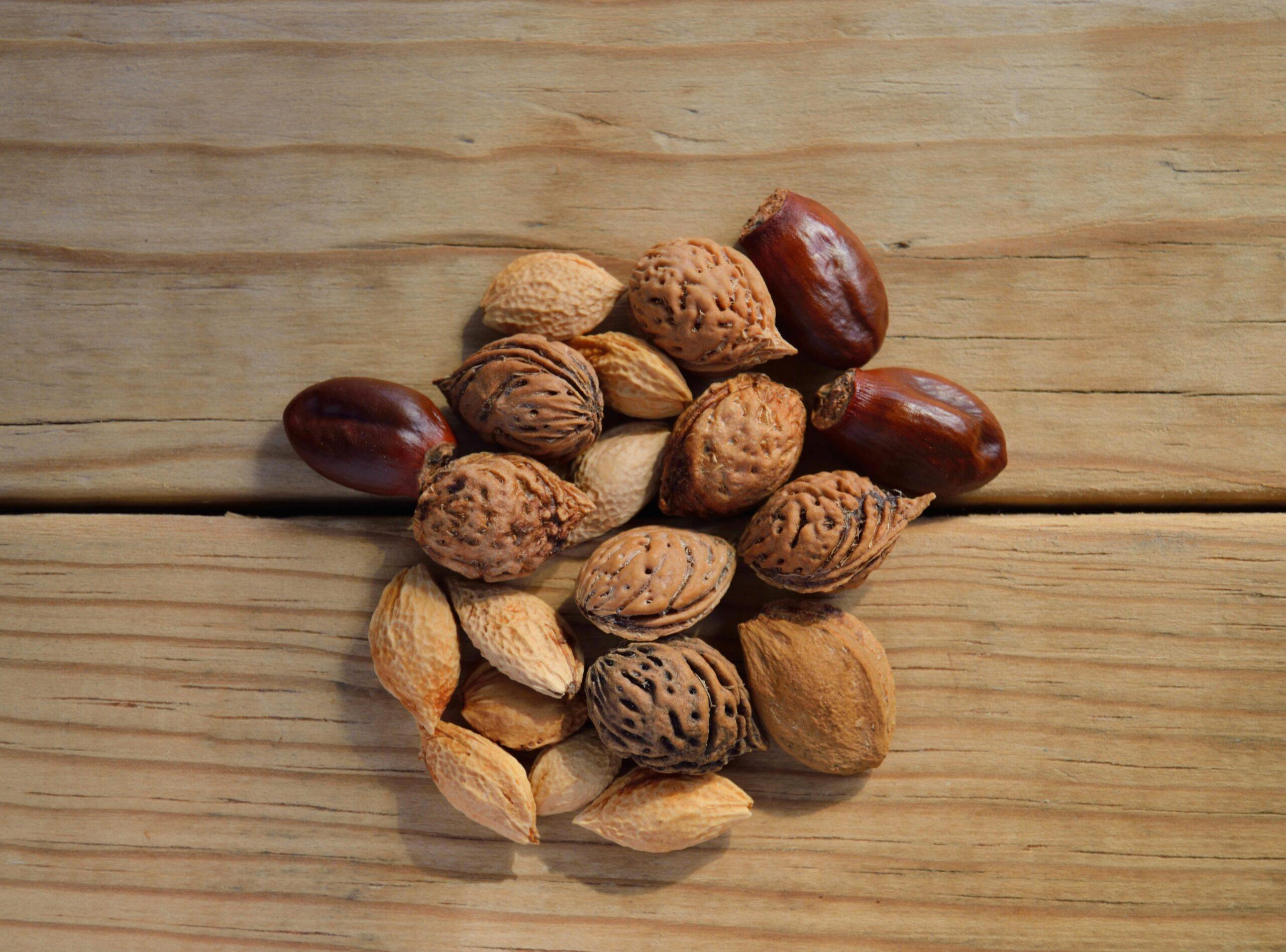 Close-up of assorted nuts and seeds on a rustic wooden table.